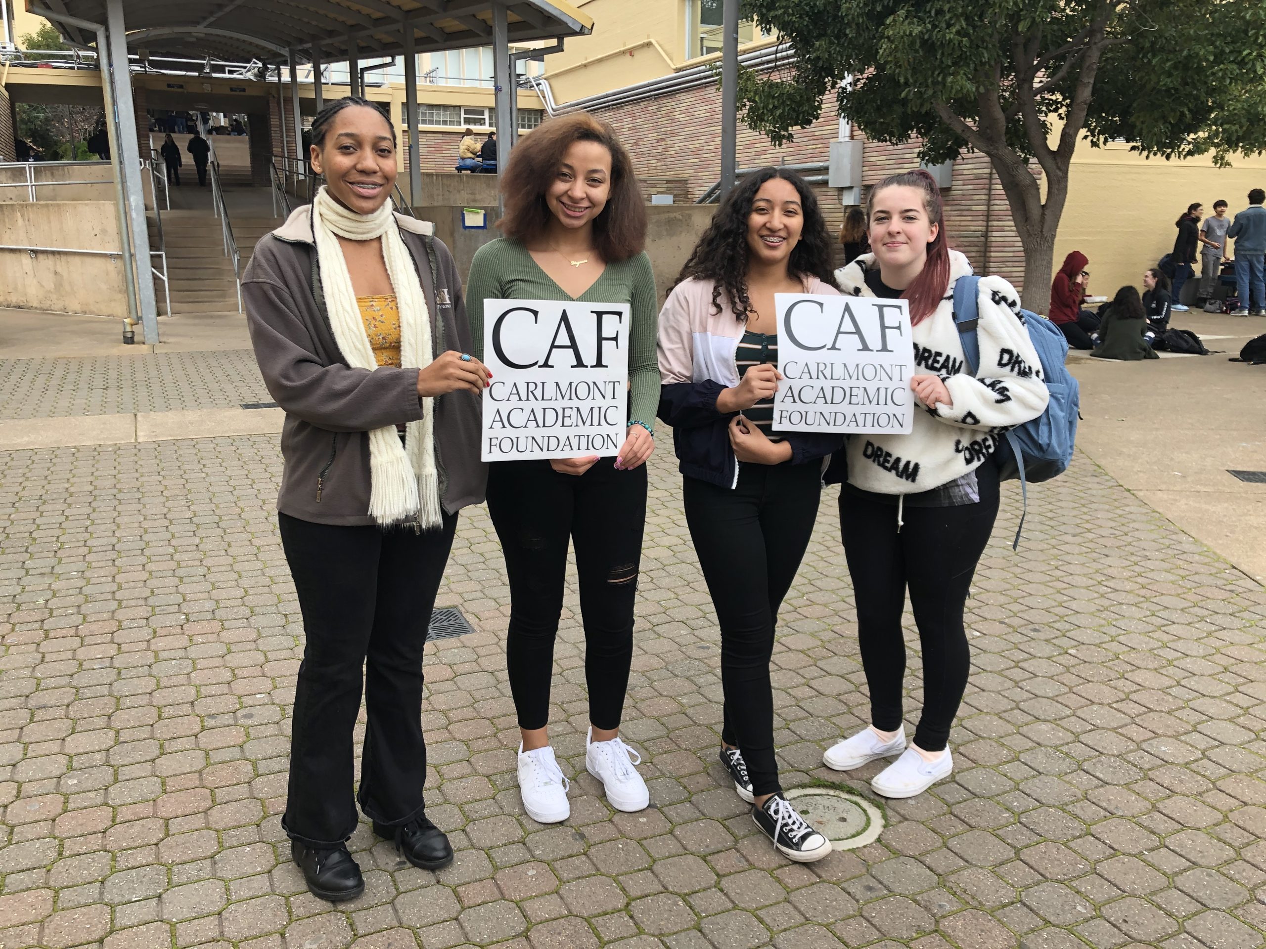 Four Carlmont students holding CAF signs