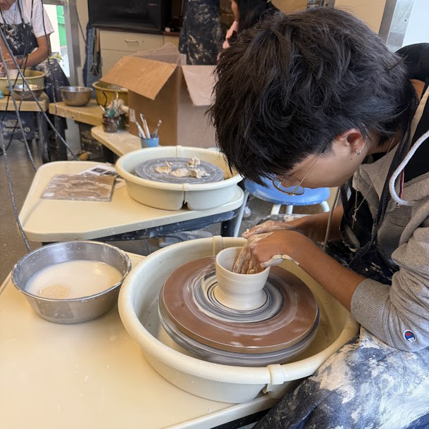Carlmont student working on a pottery throwing bat