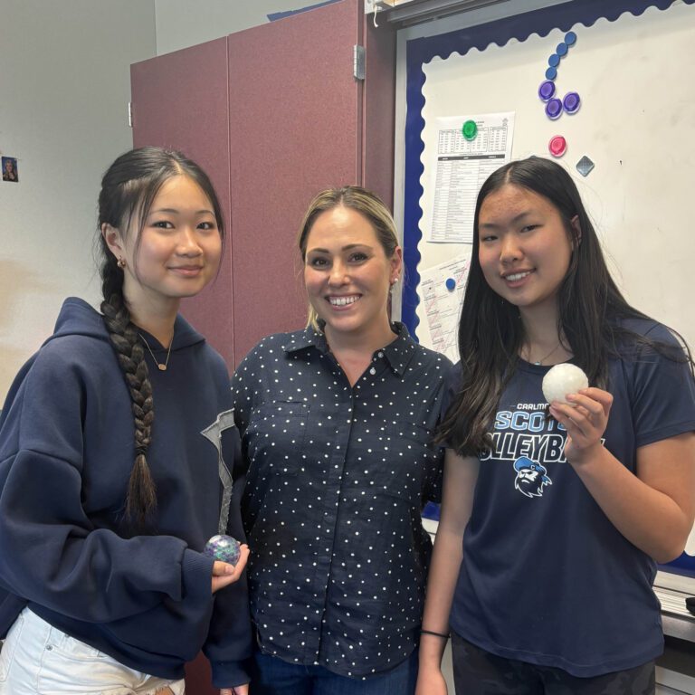 Two AS English students standing next to their teacher